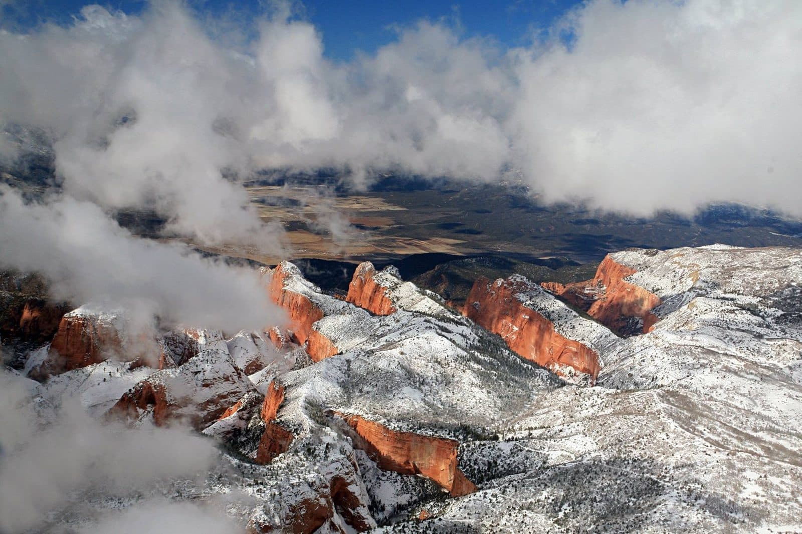 Clouds breaking over red ridges