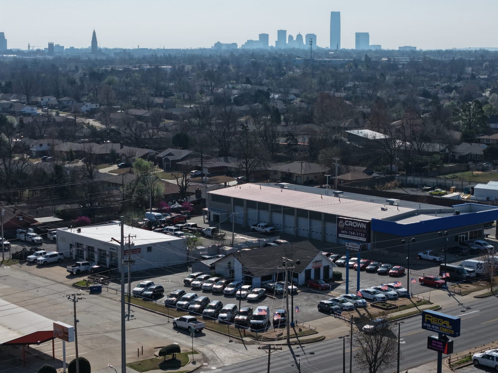Auto dealership, city skyline backdrop